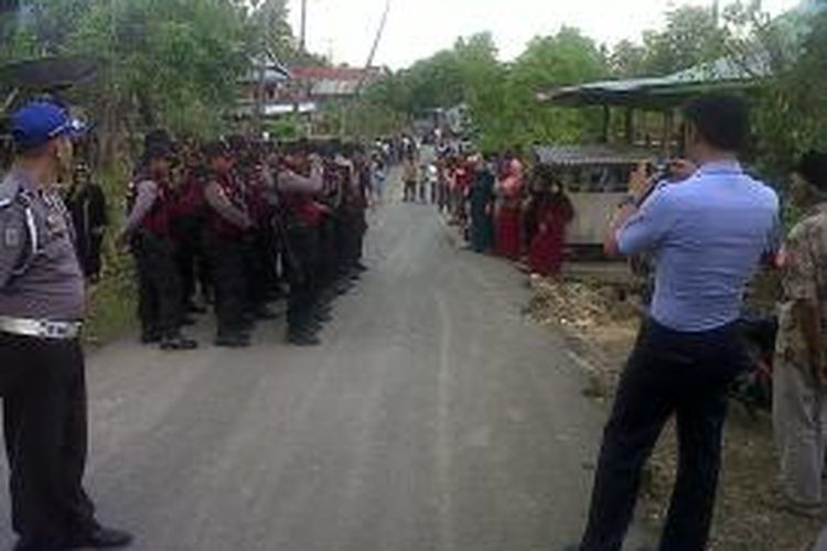 Ratusan aparat kepolisian di Kabupaten Bone, Sulawesi Selatan melakukan pengamanan di rumah duka Suardi (51) terduga teroris yang tewas ditembak tim Detasemen Khusus (Densus) 88, sambil menunggu kedatangan jenazah. Jumat, (18/10/2013).