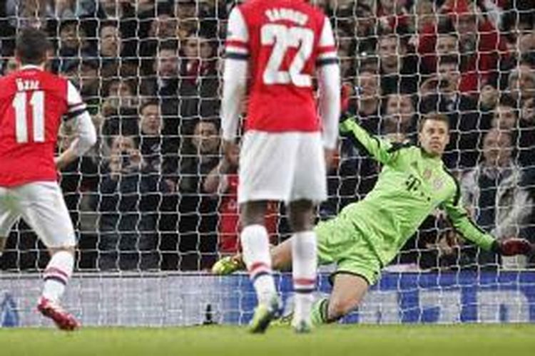 Penjaga gawang Bayern Muenchen, Manuel Neuer (kanan), menggagalkan tendangan penalti gelandang Arsenal, Mesut Oezil (kiri), pada leg pertama babak 16 besar Liga Champions di Emirates Stadium, Rabu (19/2/2014).