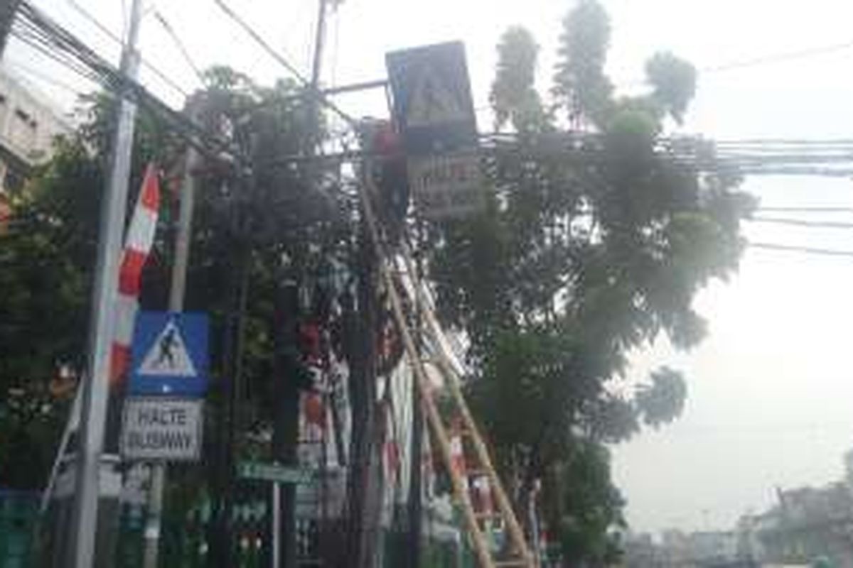 Senin (15/8/2016), kabel listrik yang menjuntai di simpang Caringin, Jakarta Pusat masih dalam perbaikan