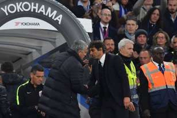 Manajer Manchester United, Jose Mourinho, membisikkan sesuatu kepada koleganya di Chelsea, Antonio Conte, setelah duel kedua tim pada partai Premier League di Stadion Stamford Bridge, Minggu (23/10/2016).