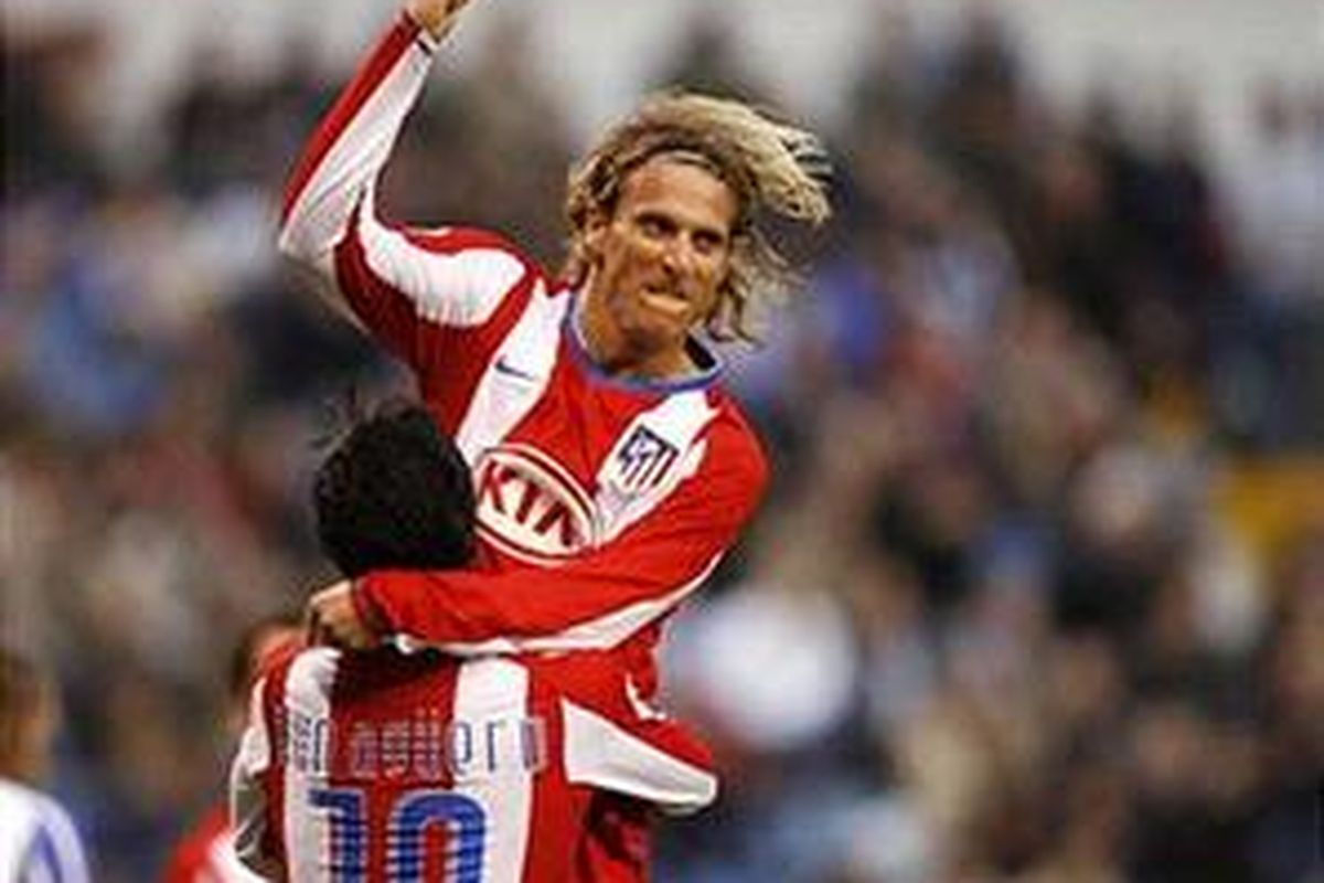 Diego Forlan digendong oleh Sergio Aguero. Duet maut ini pimpin Atletico Madrid ketika membantai Sporting Gijon 5-2.