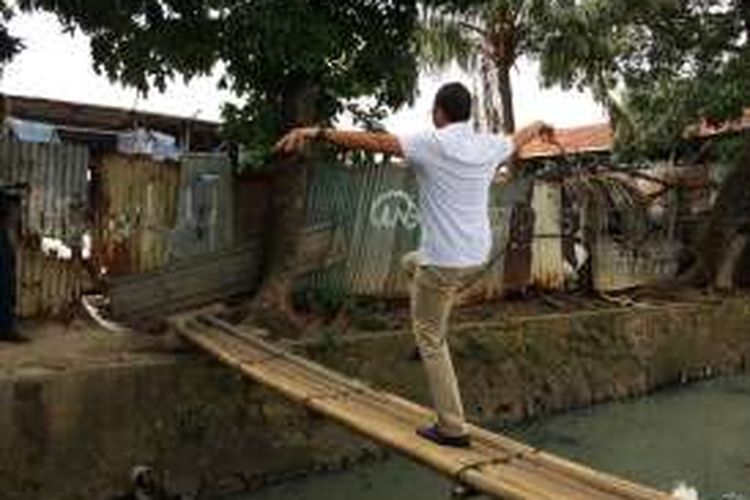 Calon wakil gubernur DKI Jakarta, Sandiaga Uno, melakukan aksi nekat kala berkampanye di Kebon Pala, Jakarta Timur, Kamis (29/12/2016). Sandiaga berdiri dengan satu kaki di atas jembatan bambu.