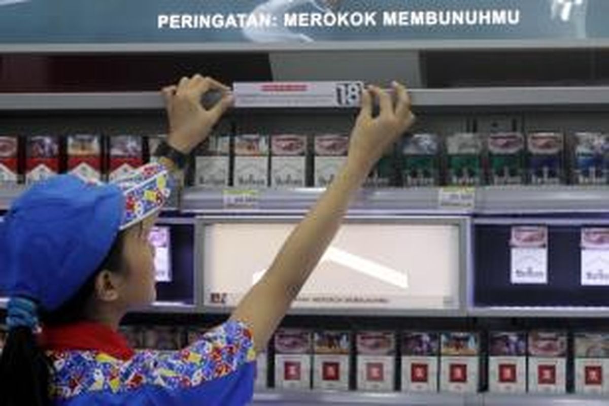 Petugas kasir memasang tanda larangan anak di bawah umur membeli rokok, di Indomaret, Jakarta Pusat, Selasa (3/11/2015). Program tersebut ditujukan untuk meningkatkan kesadaran masyarakat akan pelarangan pembelian produk tembakau oleh anak-anak di bawah 18 tahun.