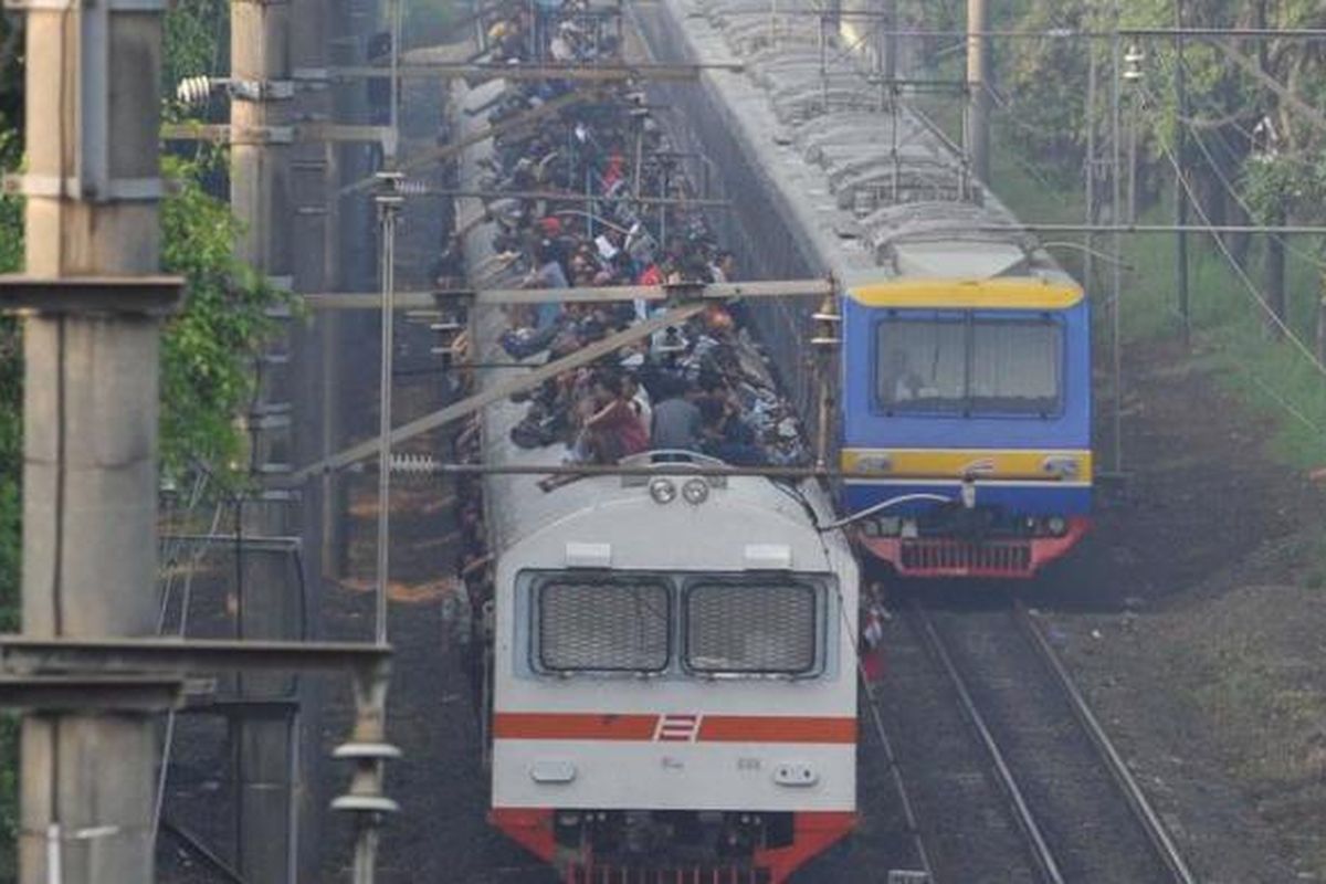Penumpang memadati atap gerbong kereta rel listrik (KRL) ekonomi Bogor-Jakarta yang melintas di kawasan Tanjung Barat, Pasar Minggu, Jakarta Selatan, Selasa (26/3/2013).