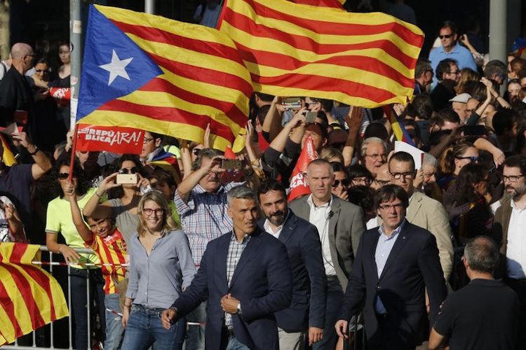 Presiden regional Catalonia Carles Puigdemont (kanan) menghadiri demo yang digelar di Barcelona pada 21 Oktober 2017.