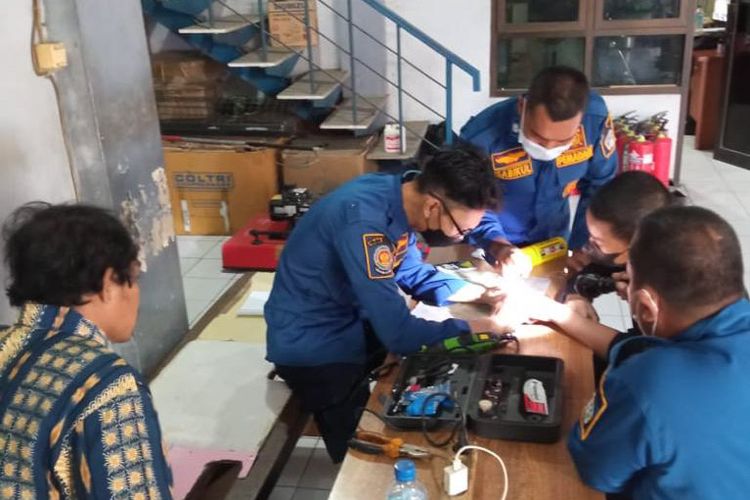 Suasana ketika petugas Damkarla Gresik membantu melepas cincin dari jari telunjuk Ahmad, Jumat (6/5/2022).