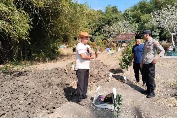 Polisi dan kepala desa saat melihat kondisi makam yang terbongkar, Sabtu (29/6/2024)