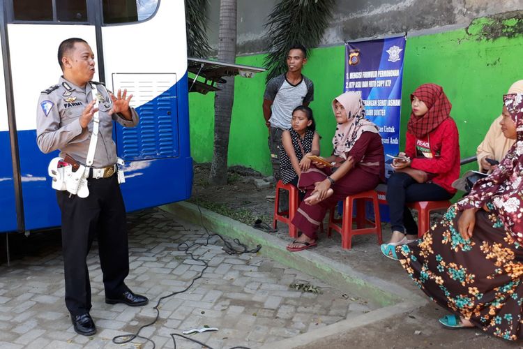 Aiptu Ramdan Fahmi saat berbagi ilmu dengan warga Gorontalo yang mengantre layanan perpanjangan SIM di Taman Kota, Kota Gorontalo.