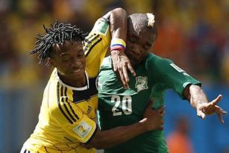 Pemain tengah Kolombia Guillermo Cuadrado (kiri) berusaha merebut bola dalam laga Grup C, Piala Dunia 2014, melawan Pantai Gading, di Mane Garrincha National Stadium in Brasilia, 19 Juni 2014.