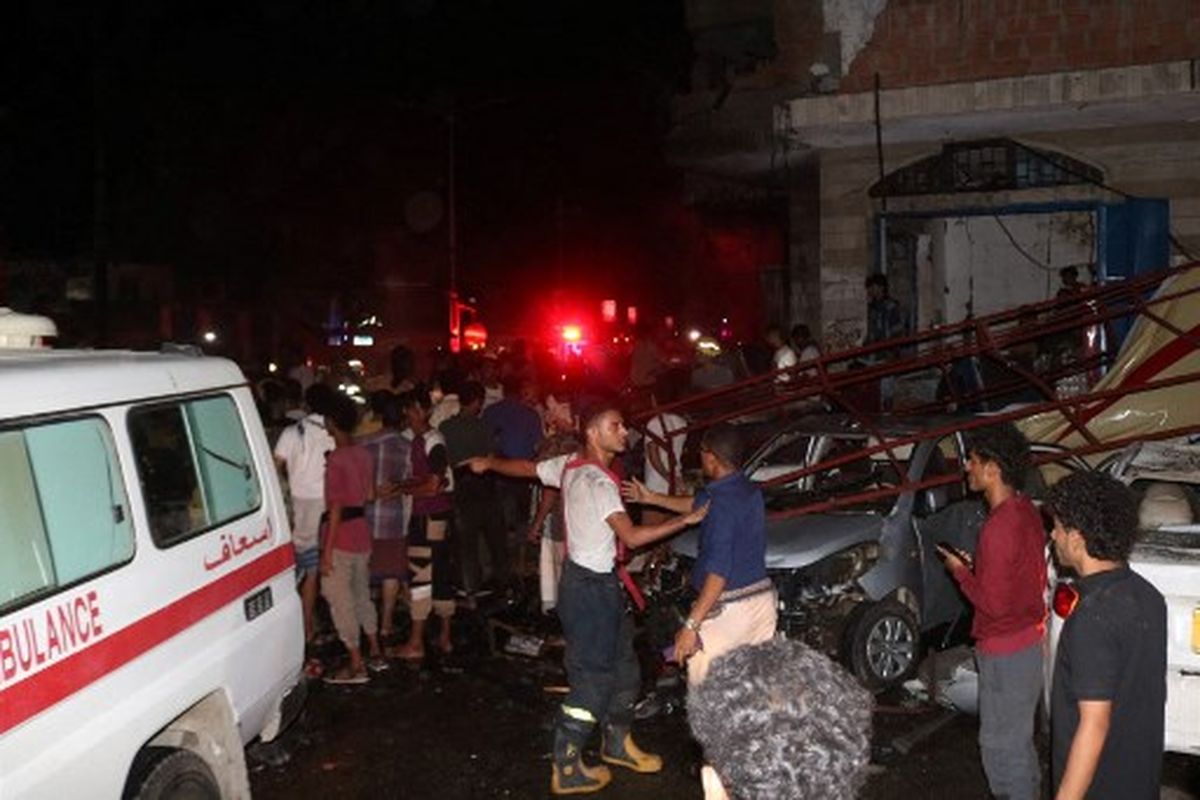 Staf layanan darurat Yaman dan pengamat berkumpul di lokasi ledakan dekat bandara kota selatan Aden, pada 30 Oktober 2021. - 