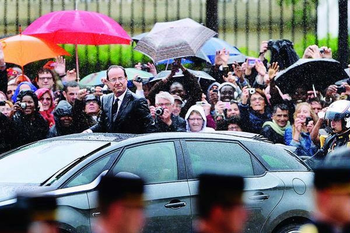 Dalam guyuran hujan gerimis, Presiden Perancis Francois Hollande dengan mobil hibrida Citroen DS5  menyapa rakyat Perancis di Champs-Elysee Avenue, Paris, setelah diambil sumpahnya sebagai  Presiden Perancis, Selasa (15/5).