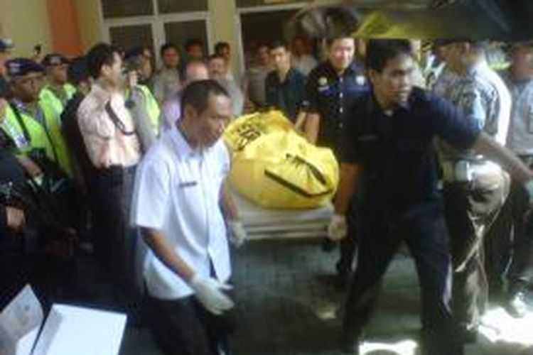Petugas RS Bhayangkara Kota Kediri, Jawa Timur, sedang mengangkat kantong jenazah yang berisi mayat terduga teroris yang tewas dalam penyergapan di Tulungagung, Senin (22/7/2013). Jenazah akan dibawa ke RS Polda Jatim di Surabaya.