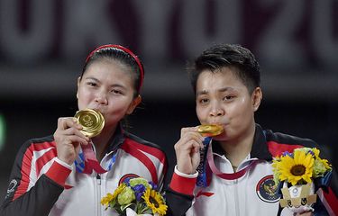 Pebulu tangkis ganda Putri Indonesia Greysia Pollii (kiri) dan Apriyani Rahayu mencium medali emas yang berhasil mereka raih untuk nomor bulutangkis ganda putri Olimpiade Tokyo 2020 di Musashino Forest Sport Plaza, Tokyo, Jepang, Senin (2/8/2021). Greysia Pollii/Apriyani Rahayu berhasil meraih medal emasi setelah mengalahkan Chen/Jia Yi Fan dua set langsung dengan skor 21-19 dan 21-15.