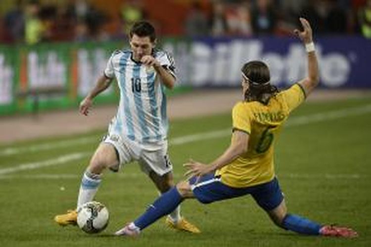 Penyerang Argentina, Lionel Messi (kiri), mencoba menggiring bola melewati bek Brasil, Luis Felipe, pada pertandingan persahabatan, di National Stadium, Beijing, Sabtu (11/10/2014).