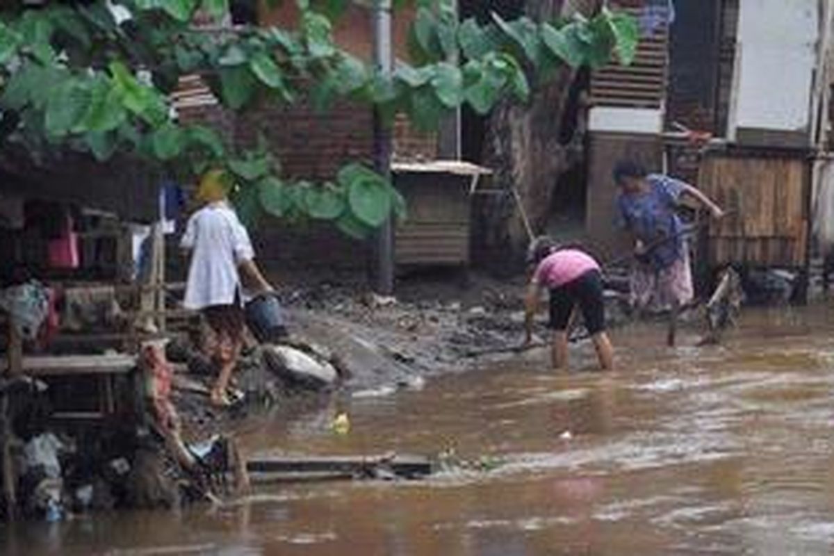 Warga membersihkan lumpur bekas banjir di halaman belakang rumah mereka yang berada di tepi Sungai Ciliwung di Bukit Duri, Jakarta, Senin (26/11/2012). Meskipun banjir telah surut, warga di bantaran Ciliwung masih mewaspadai banjir susulan karena masih tingginya curah hujan.

