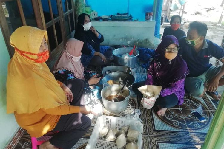 BUNGKUS NASI—Warga Kelurahan Mojorejo,  Kecamatan Taman, Kota Madiun, Jawa Timur nampak sibuk  membungkus nasi lengkap bersama lauknya untuk dibagikan bagi warga tak mampu yang terdampak pandemi Covid-19.