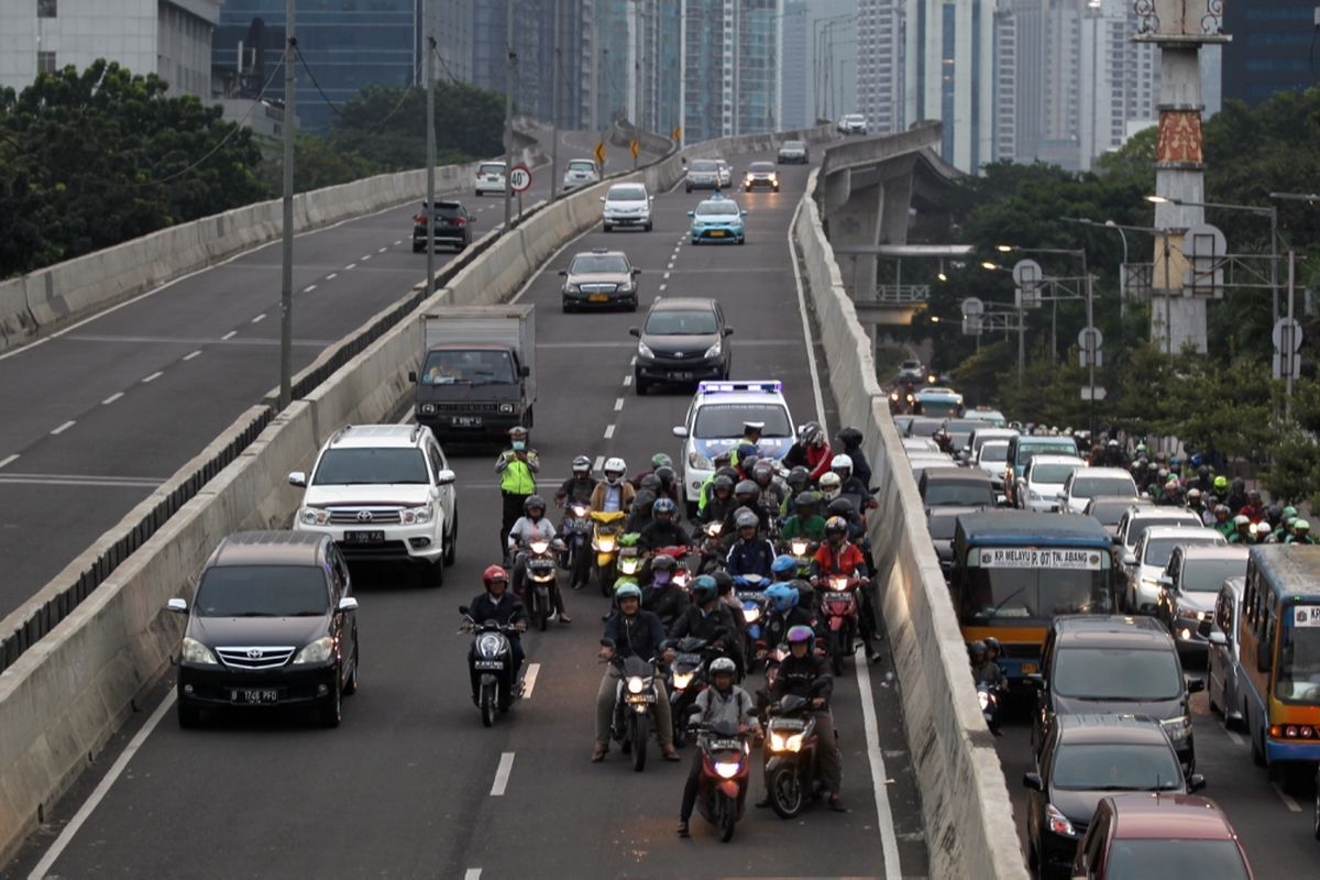 Polisi melakukan razia sepeda motor yang nekat menerobos ke jalan layang non tol (JLNT) Kampung Melayu-Tanah Abang, Jakarta, Selasa (25/7/2017). Pengendara motor masih nekat memasuki dan melintasi JLNT tersebut baik dari arah Tanah Abang maupun Kampung Melayu. KOMPAS IMAGES/KRISTIANTO PURNOMO