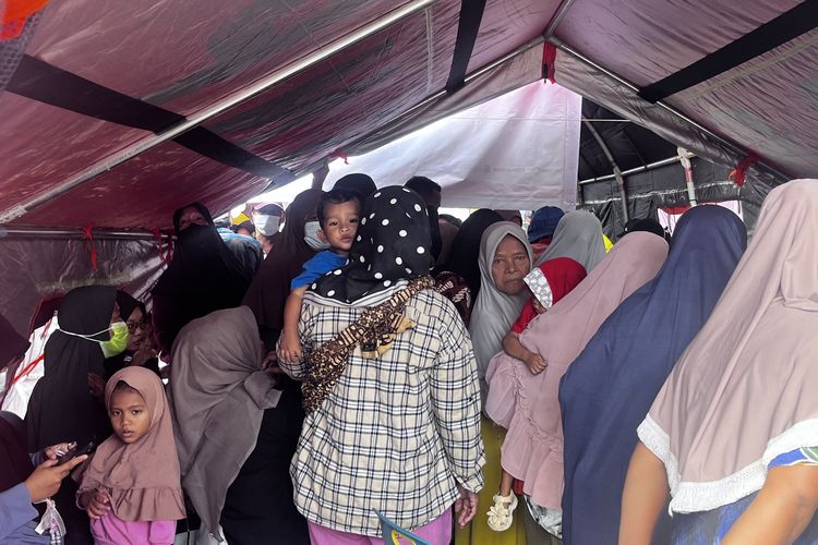 Korban banjir bandang Aceh, Muhammad Abianda Saka terkulai di gendongan ibunya, Irawati saat menunggu panggilan antrean obat di Pos Kesehatan yang dibuka BPH Migas dan Kementerian ESDM di kawasan Huntara Dannatara, Aceh Tamiang, Aceh, Sabtu (14/2/2026).
