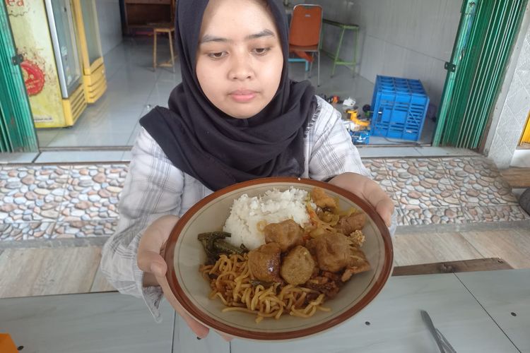Salah satu pembeli di WM Ngiras Roso, Salsabila Nura, mencoba menu makan seharga Rp 7.500, Selasa (23/7/2024).