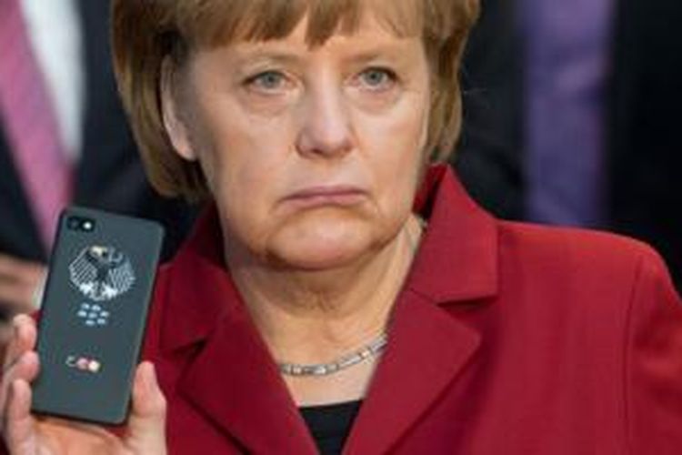 Kanselir Jerman Angela Merkel menunjukkan ponsel BlackBerry miliknya yang dilengkapi teknologi anti-sadap