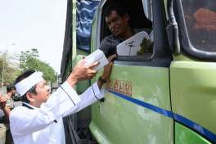 Bupati Purwakarta Dedi Mulyadi membagikan makanan ringan dan air mineral untuk pengemudi dan penumpang yang terjebak macet di Purwakarta akibat perbaikan Jembatan Cisomang, Kamis (29/12/2016).