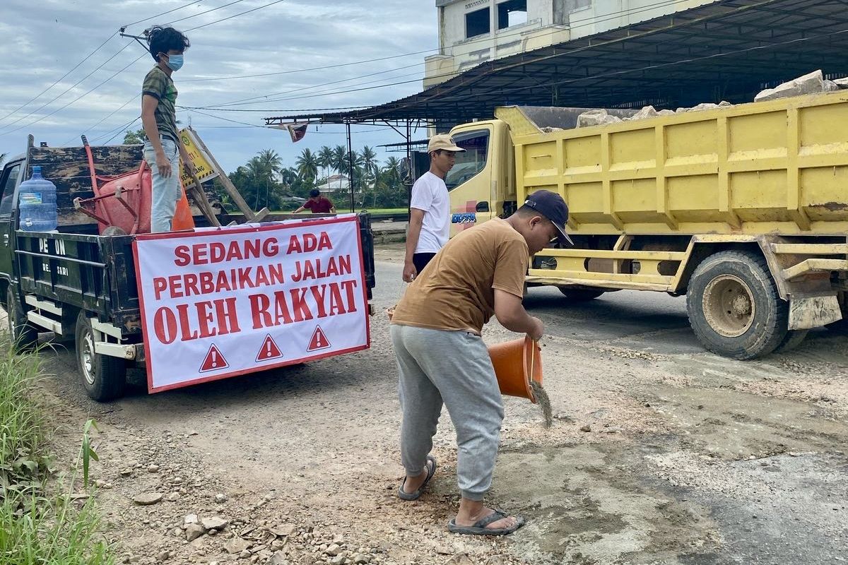 Kelompok pemuda di Kabupaten Pringsewu memperbaiki lubang jalan secara swadaya, Minggu (9/3/2025).