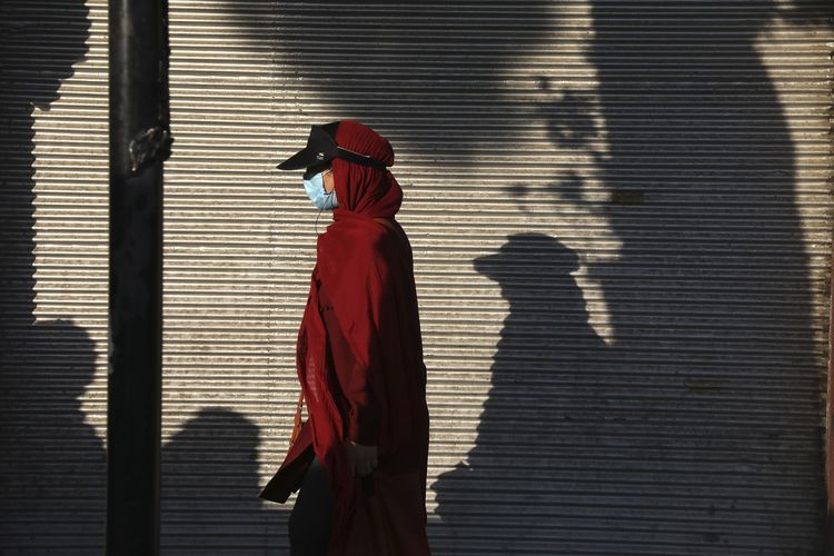 Foto pada 20 Juli 2021 memperlihatkan seorang wanita memakai masker berjalan di Teheran, ibu kota Iran. Pada Senin (2/8/2021) media pemerintah Iran melaporkan lebih dari 37.000 kasus baru, rekor harian tertinggi di negara tersebut sementara ini.