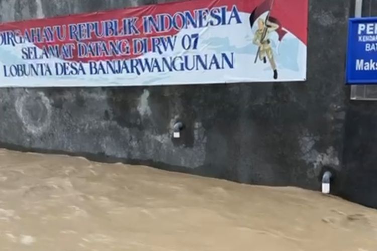 Sejumlah warga melintas jalan Desa Banjarwangunan Kecamatan Mundu Kabupaten Cirebon Jawa Barat yang terendam banjir pada Jumat (26/1/2024) petang