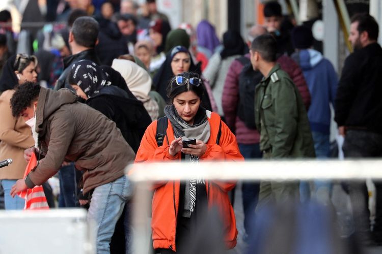 Seorang wanita Iran memeriksa ponselnya di sebuah jalan di Teheran pada 18 Januari 2024.