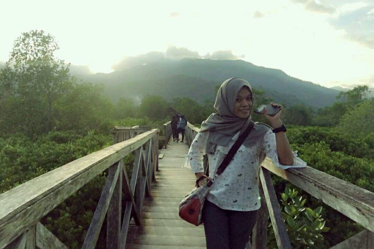 Pengunjung berfoto di Jembatan Galau di kawasan wisata mangrove Cengkrong, Kabupaten Trenggalek. Kawasan hutan bakau ini ramai dikunjungi wisatawan, khususnya saat hari libur.