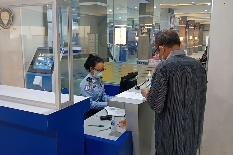Seorang pemohon paspor mengambil nomor antrian di Kantor Imigrasi Kelas I Khusus Medan pada Rabu (27/4/2022) pagi.