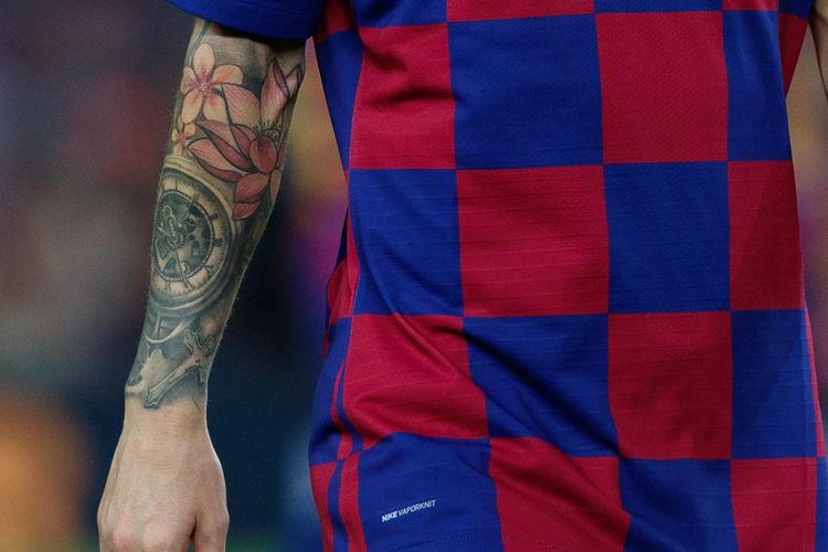 Tato bergambar jam saku di tangan kanan Lionel Messi yang dikelilingi bunga mawar merah, lotus merah muda, dan bunga oranye. 