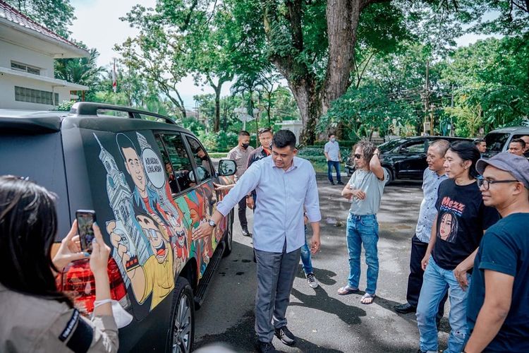 Wali Kota (Walkot) Kota Medan Bobby Nasution berdiri di depan mobil dinas miliknya yang telah dimural oleh generasi muda. 