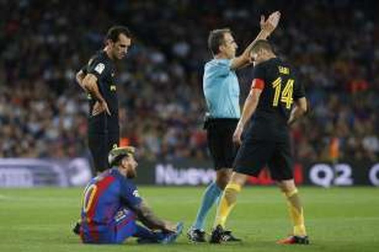 Pemain andalan FC Barcelona, Lionel Messi, duduk di lapangan lantaran mengalami cedera pada laga La Liga kontra Atletico Madrid, di Stadion Camp Nou, Rabu (21/9/2016) atau Kamis dini hari WIB.