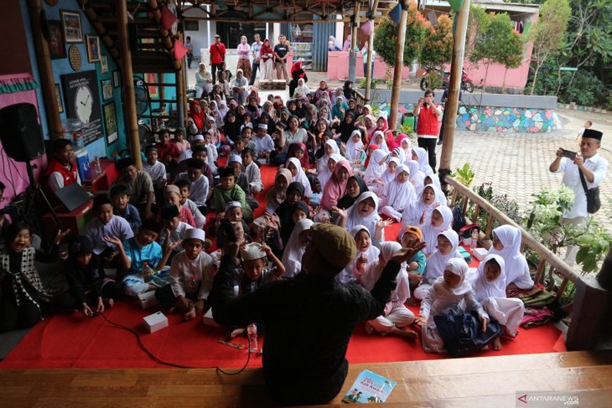 Kak Awam di tengah anak-anak yang semangat menyimak dongengnya pada acara Kampung Dongeng Peduli, Sabtu (23/3/2019) di Ciputat, Tangerang Selatan. 