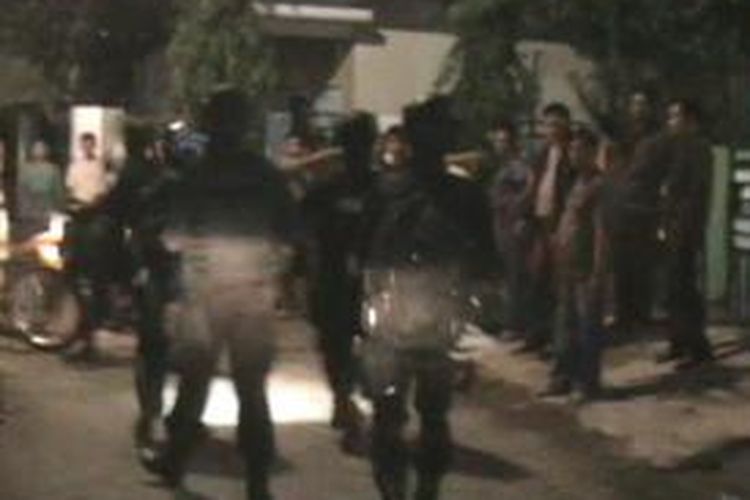 Dengan bersenjata lengkap, polisi sedang berupaya mengevakuasi seorang oknum polisi yang dikepung warga setelah sebelumnya membacok dua orang warga. Senin, (26/05/2014).