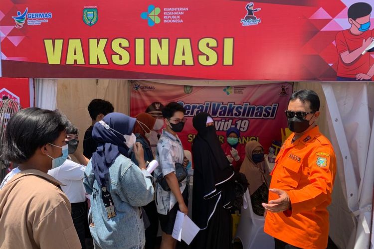 VAKSINASI—Walikota Madiun, Maidi (berkacamata hitam) memantau warga yang antri  vaksinasi gratis di gerai vaksin yang berada di pusat keramaian Kota Madiun, Sumber Umis di Jalan Pahlawan, Selasa (12/10/2021).