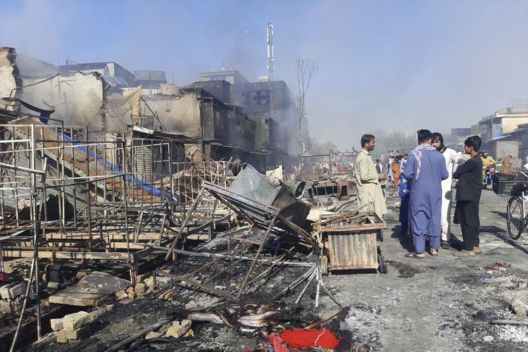 Warga Afghanistan memeriksa toko-toko yang hancur akibat bentrokan antara Taliban dengan tentara pemerintah di kota Kunduz, Minggu (8/8/2021). Taliban hari itu merebut sebagian besar Kunduz, termasuk kantor pemerintah dan markas polisi.