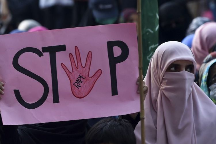 Seorang pendukung partai politik Islam Pakistan Jamaat-e-Islami (JI) memegang plakat bertuliskan Berhenti selama protes terhadap dugaan pemerkosaan berkelompok terhadap seorang wanita, di Lahore pada 17 September 2020. 