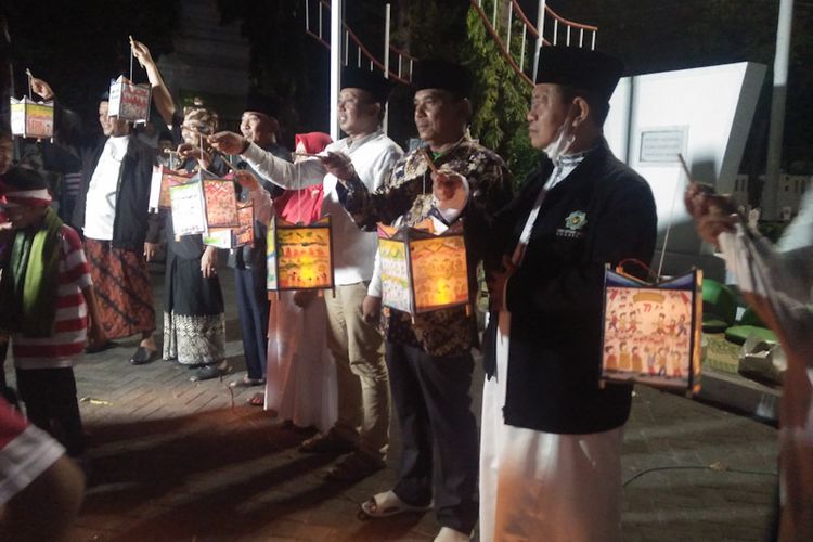 Doa bersama sembari membawa damar kurung yang dilakukan siswa dan jajaran MINU Tratee Putra Gresik, di Taman Makam Pahlawan (TMP) Gresik, Jumat (19/8/2022) malam. 