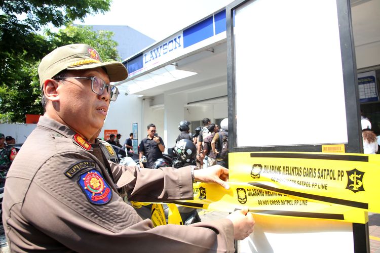 Pemerintah Kota Surabaya melakukan penyegelan terhadap toko swalayan yang tidak memiliki juru parkir resmi. 