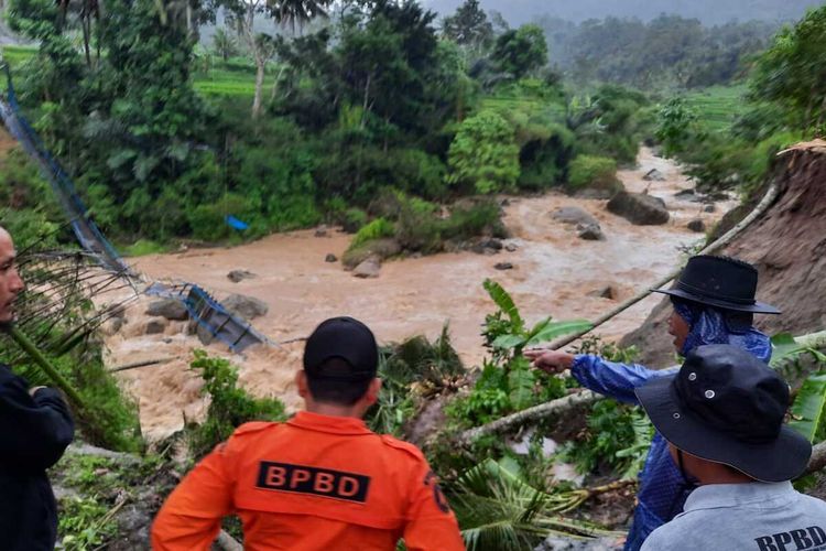 Sejumlah personel BPBD memantau kondisi jembatan gantung yang putus diterjang banjir bandang di wilayah Kecamatan Cidaun. Akibatnya, seribuan warga dari dua desa terancam terisolasi.