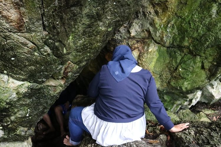 Pengunjung berusaha masuk ke damal gua tempat kelahiran Sisingamangaraja I