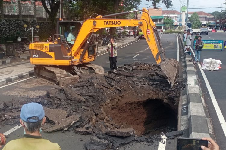Alat berat berupa ekskavator diturunkan oleh Pemkot Malang untuk penanganan awal jalan ambles yang terjadi di Jalan Bandung, Kota Malang atau depan Sekolah TK, SD dan SMP Karya Sang Timur pada Kamis (7/12/2023).
