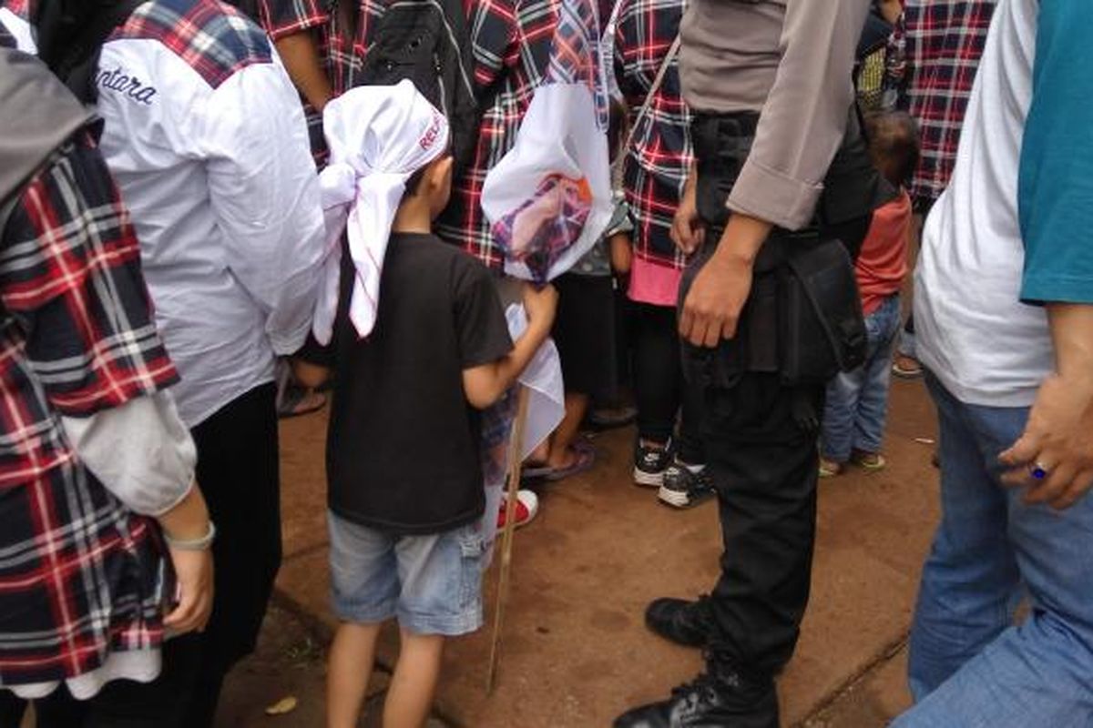 Seorang anak kecil yang memakai atribut pasangan calon gubernur dan wakil gubernur DKI Jakarta nomor pemilihan 2, Basuki Tjahaja Purnama dan Djarot Saiful Hudayat di konser 