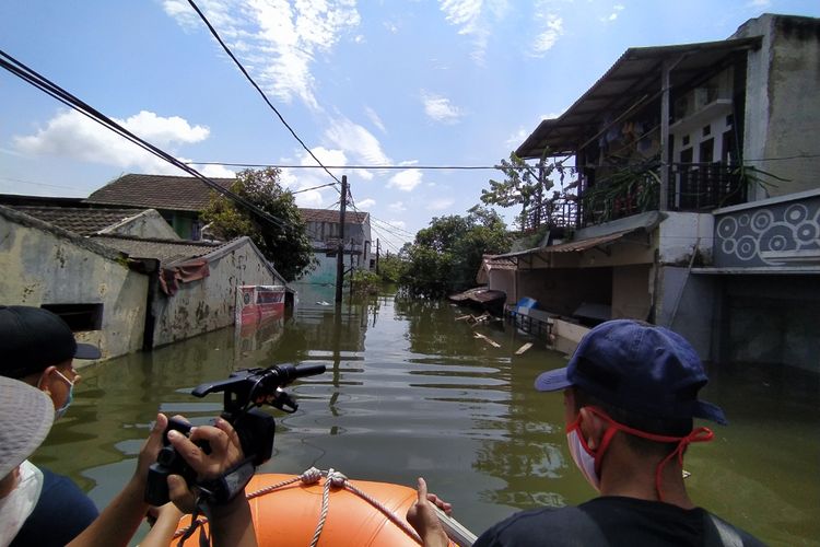 Banjir yang masih menggenangi wilayah RW 011, Kelurahan Periuk, Kecamatan Periuk, Kota Tangerang, Banten sampai Senin (22/2/2021) siang sejak Sabtu (20/2/2021). Banjir di wilayah tersebut akibat luapan Kali Cirarab dan hujan dengan intensitas tinggi pada Sabtu pekan lalu.