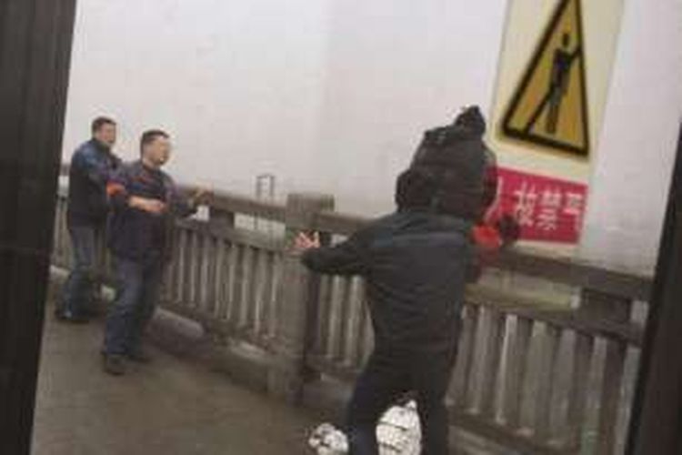 Dari foto yang diambil seorang penumpang bus, terlihat aksi sang pengemudi saat menyelamatkan seorang perempuan yang akan bunuh diri dengan cara terjun ke Sungai Yangtze di kota Nanjing, China.