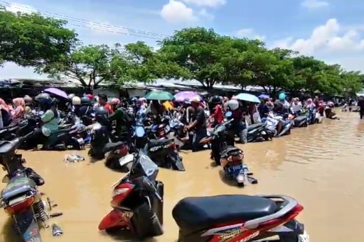 Sejumlah pekerja pabrik di Desa Sidaresmi Kecamatan Pabedilan Kabupaten Cirebon Jawa Barat berusaha mengeluarkan sepeda motor mereka dari kepungan banjir, Kamis (6/3/2024) siang.