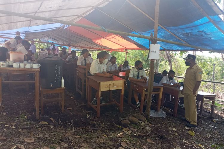 sebanyak 47 siswa dan siswi SMPN 04 Kota Komba melaksanakan Ujian Akhir Sekolah (UAS) berbasis digital dibawah tenda darurat di tengah hutan di Gunung Wokonggoro, Kampung Gurung, Desa Gunung, Kecamatan Kota Komba, Kabupaten Manggarai Timur, NTT, Senin, (12/4/2021). Ujian dilaksanakan dari Senin, (12/4/2021) sampai Kamis, (15/4/2021). (KOMPAS.com/MARKUS MAKUR)