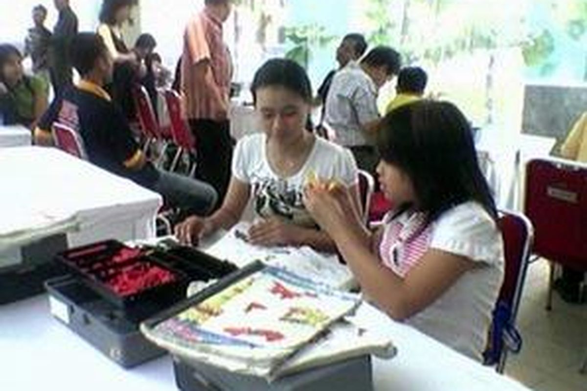 Seorang peserta bersama dengan ibunya mengikuti kontes Robot Explorer cabang Sense of Your Family, Minggu (7/9) di Marketing Gallery Podomoro City, Jakarta.